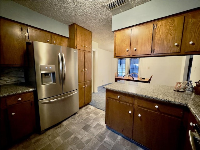 1203 N Hackberry St, Bishop, TX 78343 - kitchen with stainless steel fridge with ice dispenser, a textured ceiling, and visible vents
