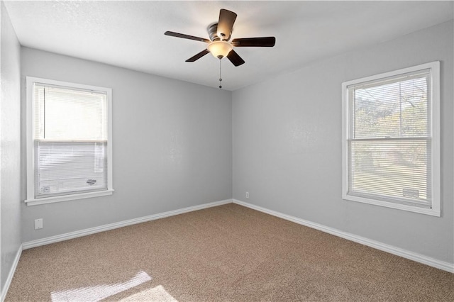 carpeted empty room featuring ceiling fan and a healthy amount of sunlight