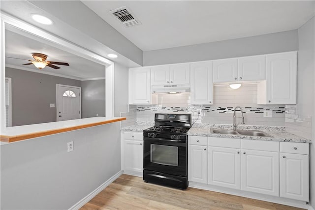 kitchen with sink, white cabinetry, tasteful backsplash, black gas range oven, and light hardwood / wood-style floors