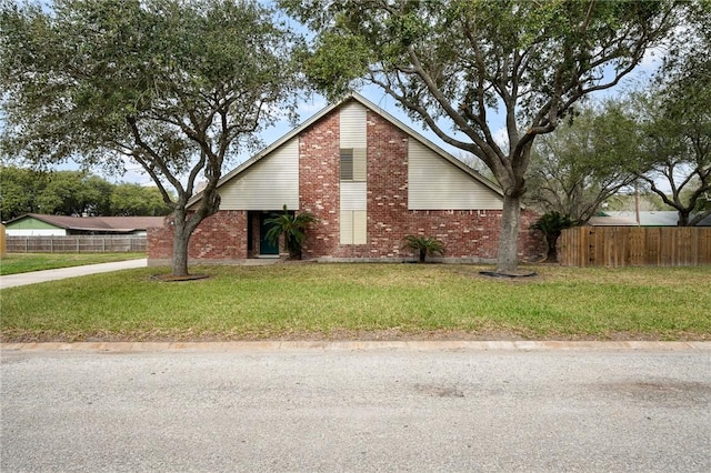 view of front of property featuring brick siding, a front yard, and fence