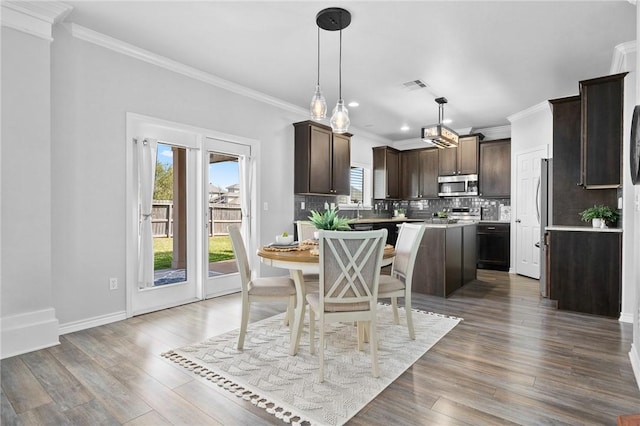 dining area with baseboards, visible vents, wood finished floors, crown molding, and recessed lighting