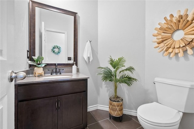 bathroom featuring tile patterned flooring, baseboards, vanity, and toilet