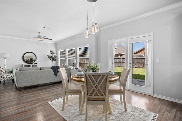 dining area featuring dark wood-style floors, ornamental molding, visible vents, and baseboards