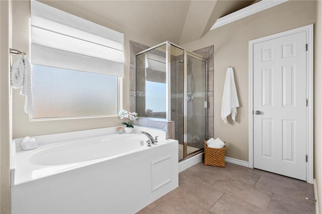 full bathroom featuring a garden tub, a shower stall, baseboards, and tile patterned flooring