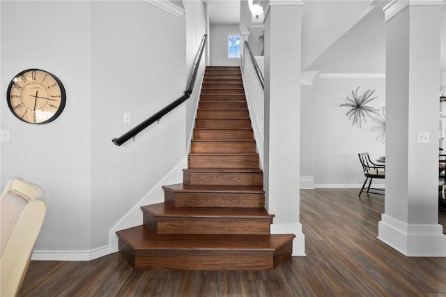 staircase featuring wood finished floors and baseboards