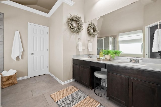 bathroom with double vanity, a shower stall, baseboards, and a sink