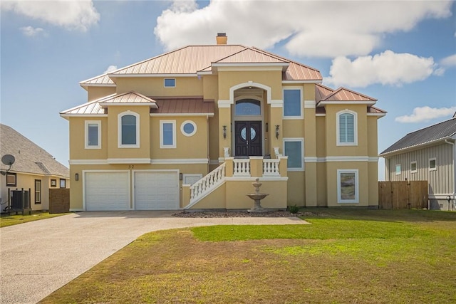 view of front of property featuring a standing seam roof, a front lawn, metal roof, and stucco siding