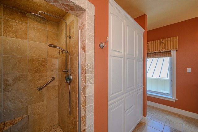 bathroom featuring tiled shower and baseboards