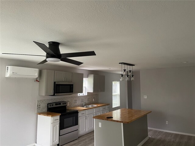 4414 Valdez Dr, Corpus Christi, TX 78416 - interior space featuring ceiling fan, baseboards, wood finished floors, butcher block countertops, and a center island