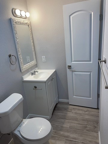 4414 Valdez Dr, Corpus Christi, TX 78416 - bathroom with toilet, vanity, wood finished floors, and baseboards