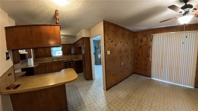 257 N 9th St, Aransas Pass, TX 78336 - kitchen featuring light flooring, ceiling fan, light countertops, water heater, and a peninsula