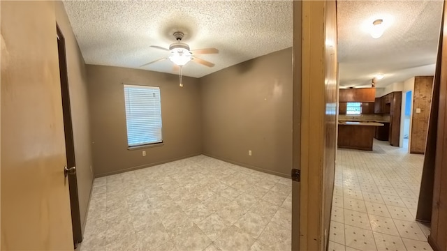 257 N 9th St, Aransas Pass, TX 78336 - empty room featuring a textured ceiling, a ceiling fan, and healthy amount of natural light