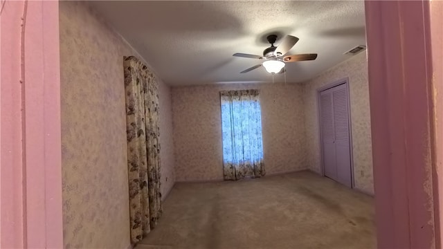 257 N 9th St, Aransas Pass, TX 78336 - unfurnished bedroom featuring carpet, a closet, a textured ceiling, and a ceiling fan