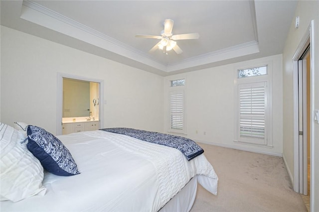 bedroom featuring baseboards, ornamental molding, a tray ceiling, and light carpet