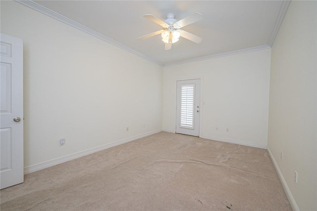 empty room featuring crown molding, baseboards, a ceiling fan, and light colored carpet