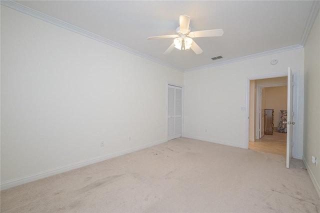 interior space featuring visible vents, baseboards, crown molding, and light carpet