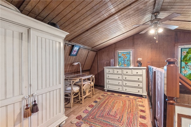 interior space with wood walls, wooden ceiling, light hardwood / wood-style floors, ceiling fan, and vaulted ceiling