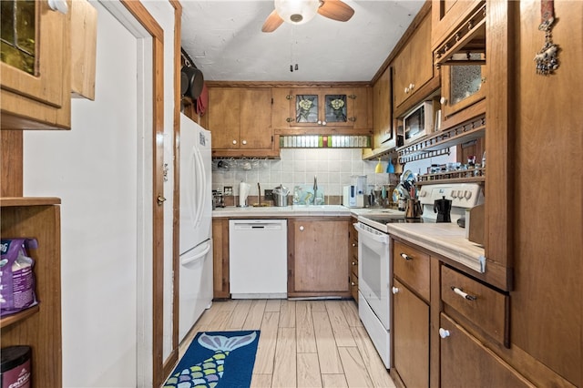 kitchen with light hardwood / wood-style floors, sink, tasteful backsplash, ceiling fan, and white appliances