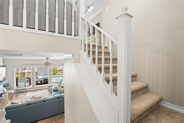 stairs featuring decorative columns, hardwood / wood-style flooring, and rail lighting