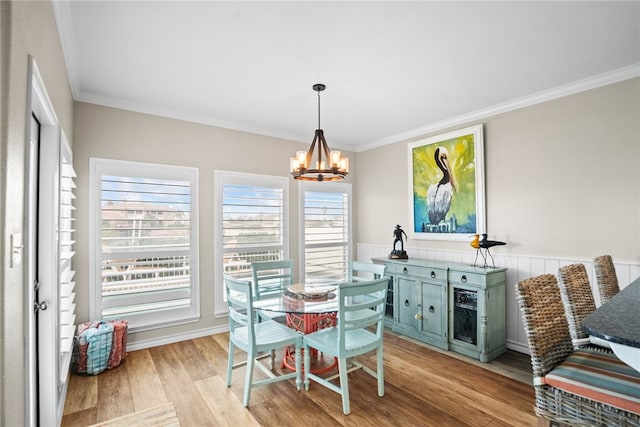 dining area featuring light hardwood / wood-style flooring, a notable chandelier, and crown molding