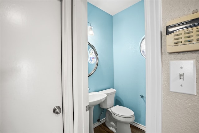 bathroom featuring hardwood / wood-style floors and toilet