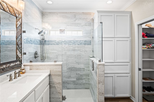 bathroom with vanity, an enclosed shower, and ornamental molding