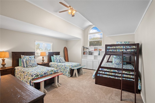 carpeted bedroom with ornamental molding, vaulted ceiling, and ceiling fan