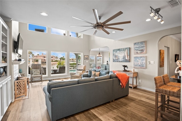 living room with light wood-type flooring, ceiling fan, and crown molding