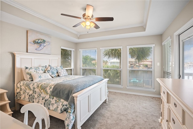 carpeted bedroom featuring ornamental molding, ceiling fan, and a raised ceiling