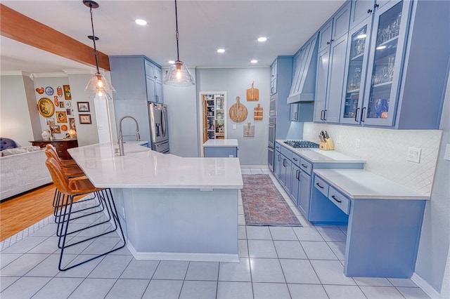7710 Cisco, Corpus Christi, TX 78413 - kitchen featuring appliances with stainless steel finishes, blue cabinets, extractor fan, decorative backsplash, and crown molding