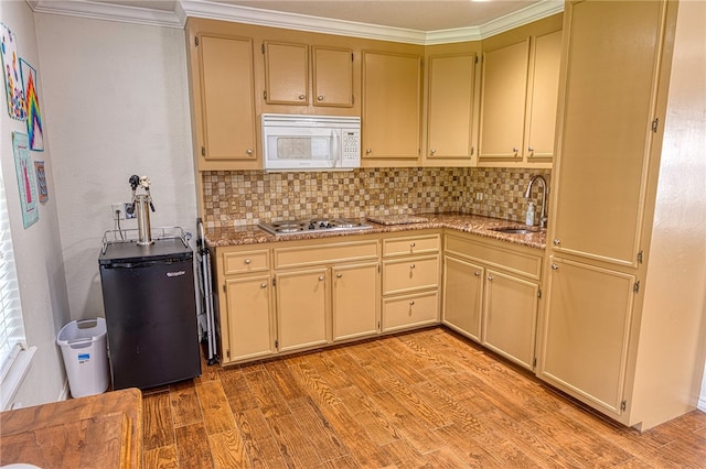 7710 Cisco, Corpus Christi, TX 78413 - kitchen featuring white microwave, cream cabinetry, light wood-style floors, decorative backsplash, and ornamental molding