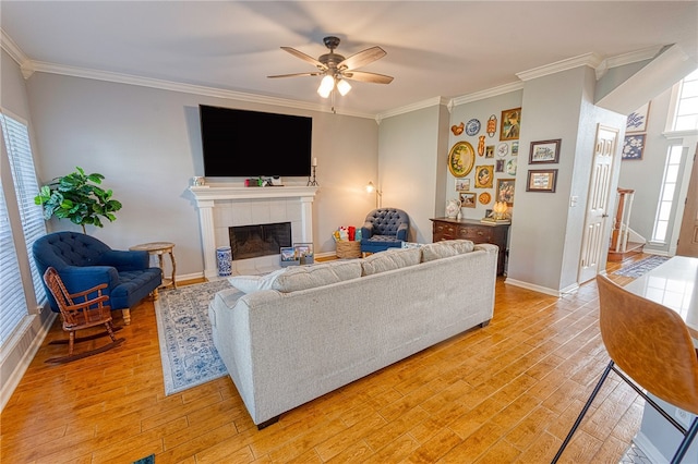 7710 Cisco, Corpus Christi, TX 78413 - living room featuring ornamental molding, light wood-style flooring, ceiling fan, and a tile fireplace