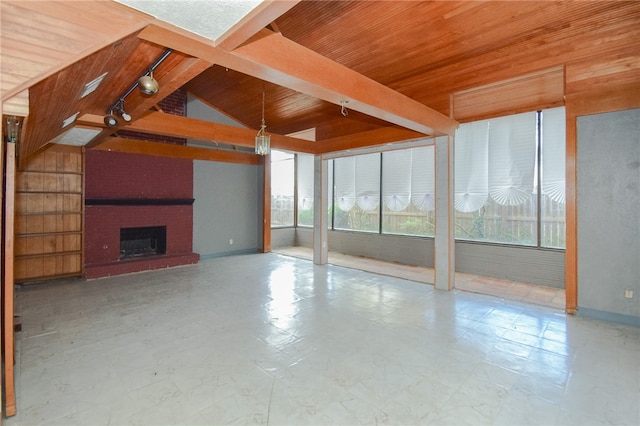 unfurnished living room featuring rail lighting, vaulted ceiling, wooden ceiling, and a fireplace