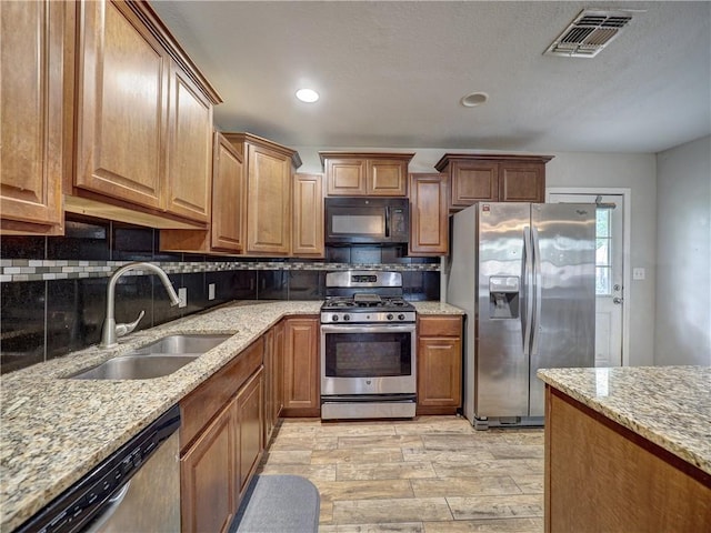 1809 Merriman Ave, Corpus Christi, TX 78412 - kitchen with a sink, visible vents, backsplash, light stone countertops, and appliances with stainless steel finishes