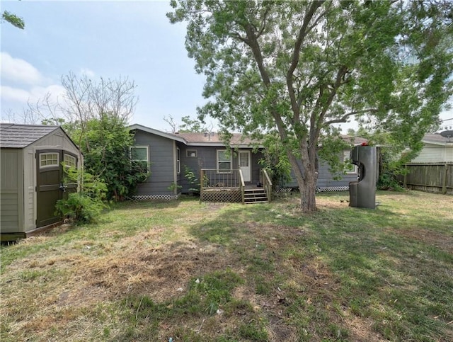 1809 Merriman Ave, Corpus Christi, TX 78412 - view of yard featuring fence, a wooden deck, a storage unit, and an outbuilding