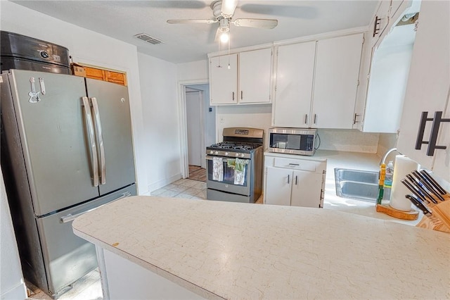 1309 Annapolis Dr, Corpus Christi, TX 78415 - kitchen featuring appliances with stainless steel finishes, light countertops, a sink, white cabinets, and ceiling fan