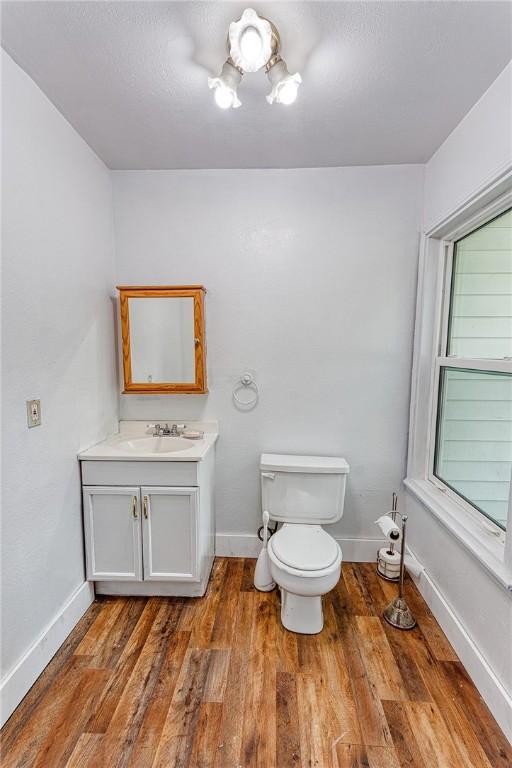 1309 Annapolis Dr, Corpus Christi, TX 78415 - bathroom with baseboards, vanity, wood finished floors, and toilet