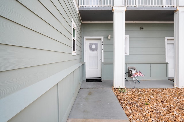 view of exterior entry featuring a balcony