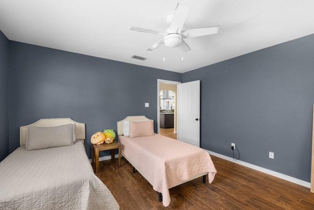 bedroom featuring a ceiling fan, baseboards, visible vents, and wood finished floors