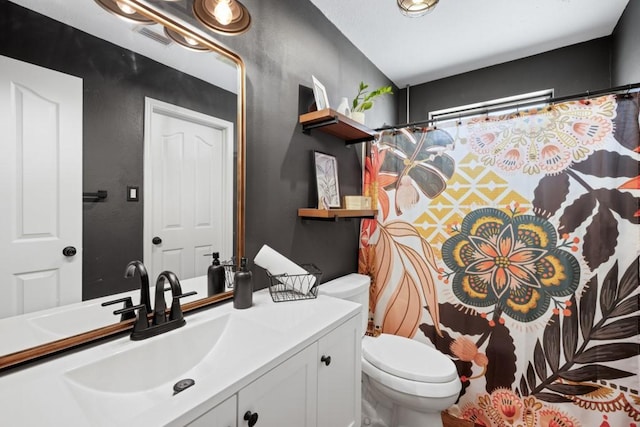 bathroom with toilet, curtained shower, and vanity