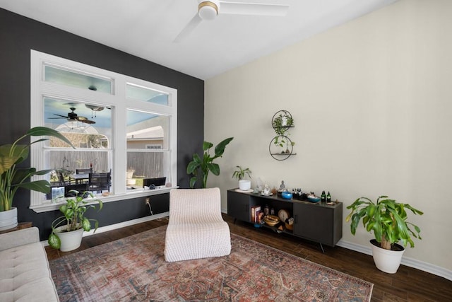 sitting room featuring ceiling fan, dark wood-type flooring, and baseboards