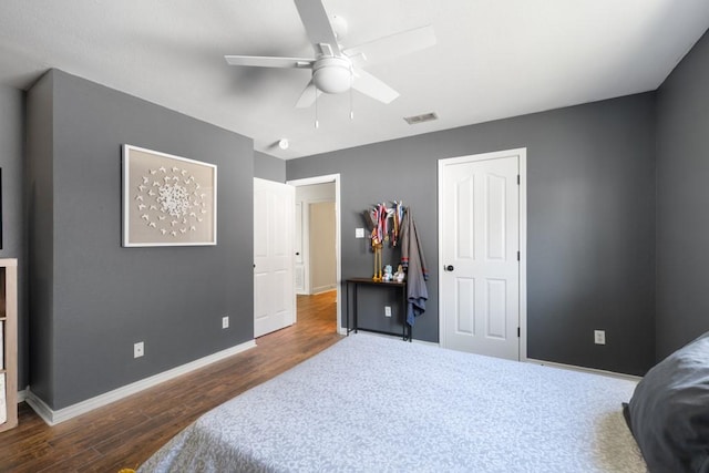 bedroom featuring dark wood-style floors, visible vents, ceiling fan, and baseboards