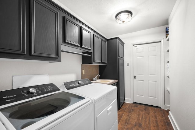 washroom featuring dark wood-type flooring, a sink, baseboards, cabinet space, and washer and clothes dryer