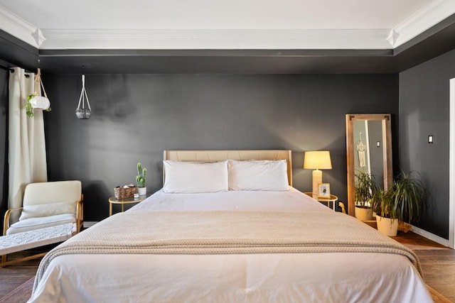 bedroom with crown molding, dark wood finished floors, and baseboards