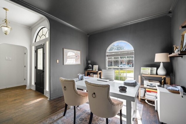 dining area with dark wood-type flooring, arched walkways, a healthy amount of sunlight, and crown molding