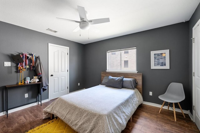 bedroom with dark wood-style floors, visible vents, baseboards, and a ceiling fan