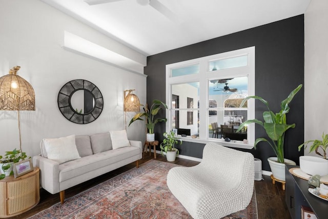 living room featuring ceiling fan and dark wood-type flooring