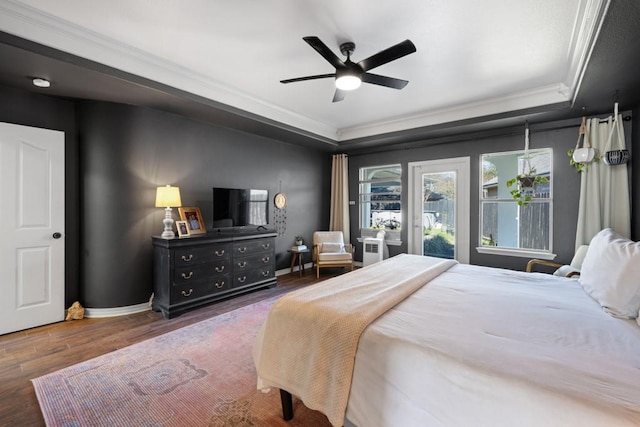 bedroom with baseboards, a raised ceiling, dark wood finished floors, access to outside, and crown molding