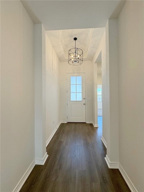 doorway with dark wood-type flooring and a chandelier