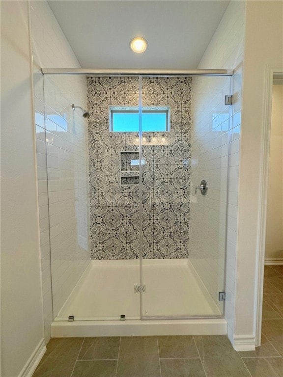 bathroom with tile patterned flooring and a shower with door